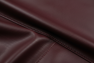 close up of high quality textured burgundy vegan leather for apparel